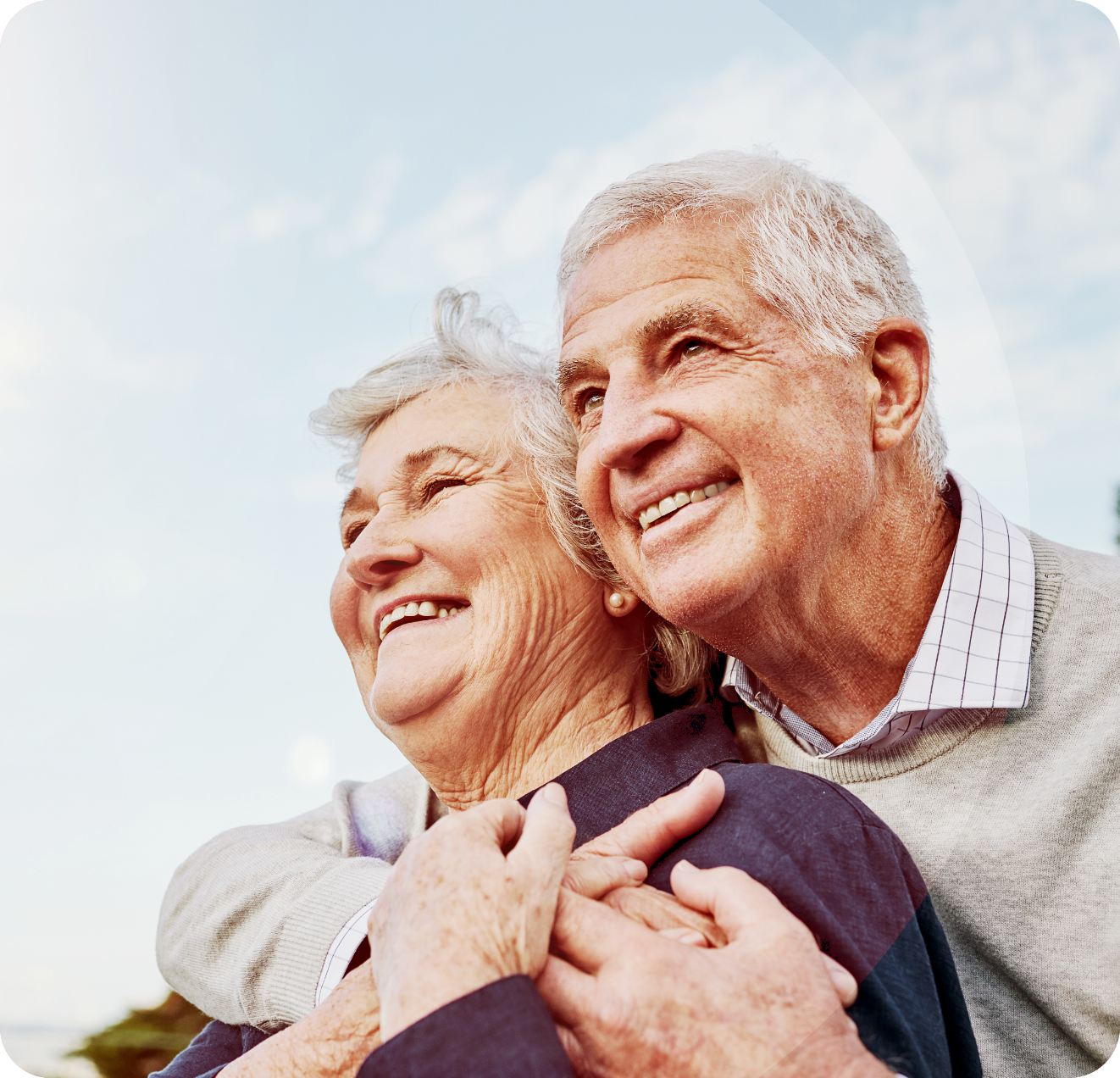 Older couple smiling with man's arms around woman, promoting life-changing mitral repair.